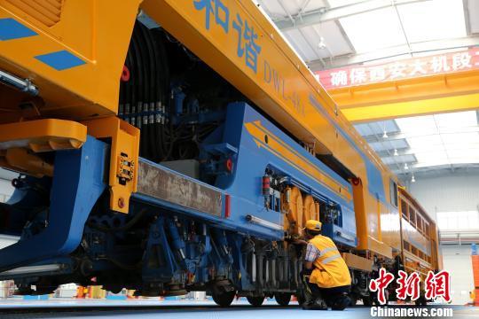 圖為工人正在清理大型養(yǎng)路機械。　張遠 攝